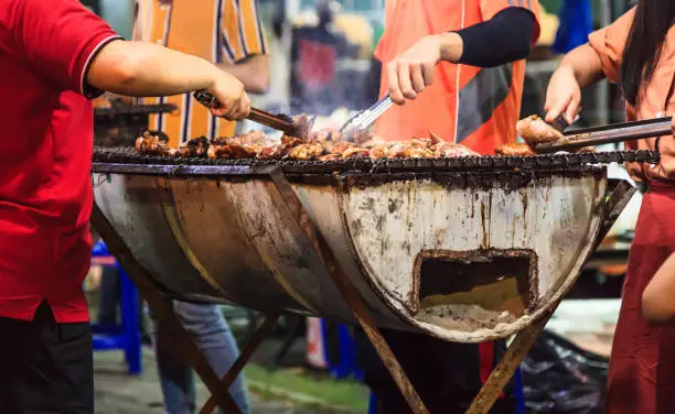 People grilling outdoors with diverse food